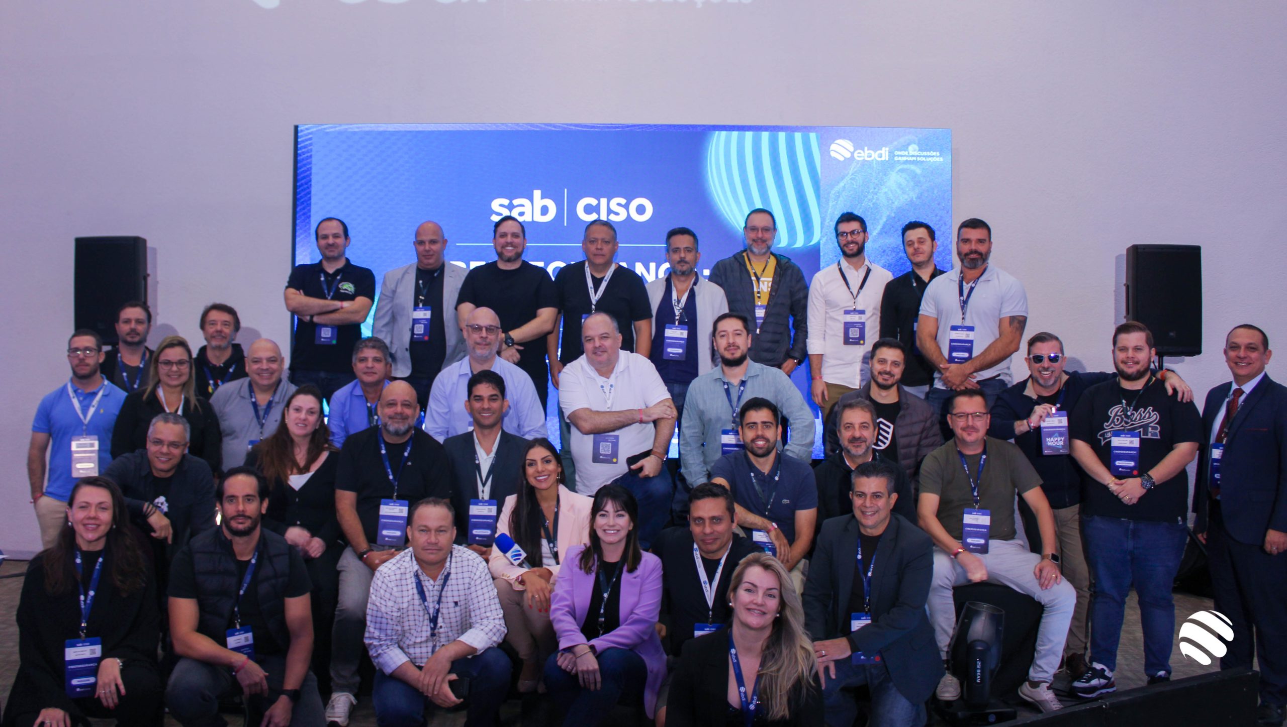 Na imagem vemos vários executivos, homens e algumas mulheres, posando para foto. Alguns estão de pé e outros estão agachados.